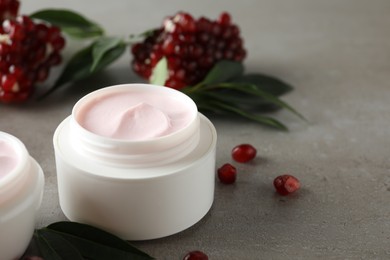 Photo of Natural facial mask, pomegranate seeds and green leaves on light grey table, closeup