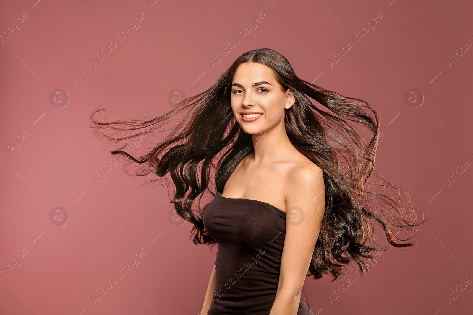 Photo of Portrait of beautiful model with gorgeous curly hair on color background