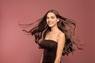 Photo of Portrait of beautiful model with gorgeous curly hair on color background