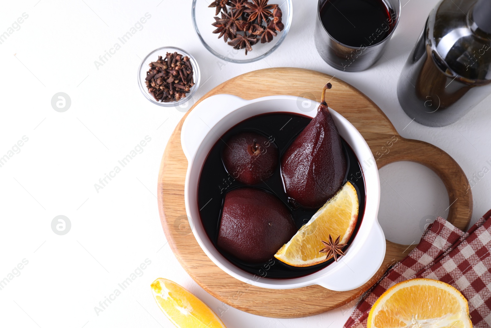 Photo of Tasty red wine poached pears in pot, orange and spices on white table, flat lay. Space for text