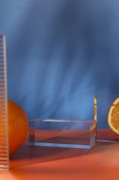 Photo of Presentation for product. Podium and tasty fresh oranges on red table against blue background, closeup. Space for text