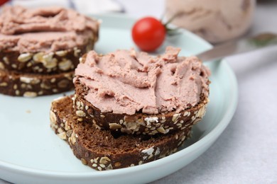 Photo of Slices of bread with delicious liverwurst on white table, closeup