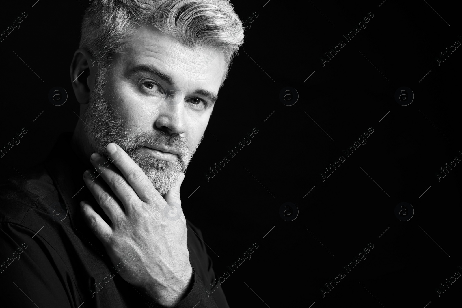 Photo of Portrait of handsome man on dark background, space for text. Black and white effect