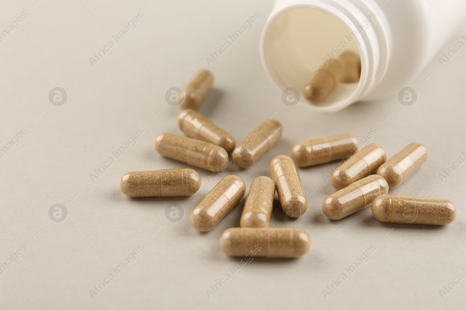 Photo of Bottle and vitamin capsules on light background, closeup