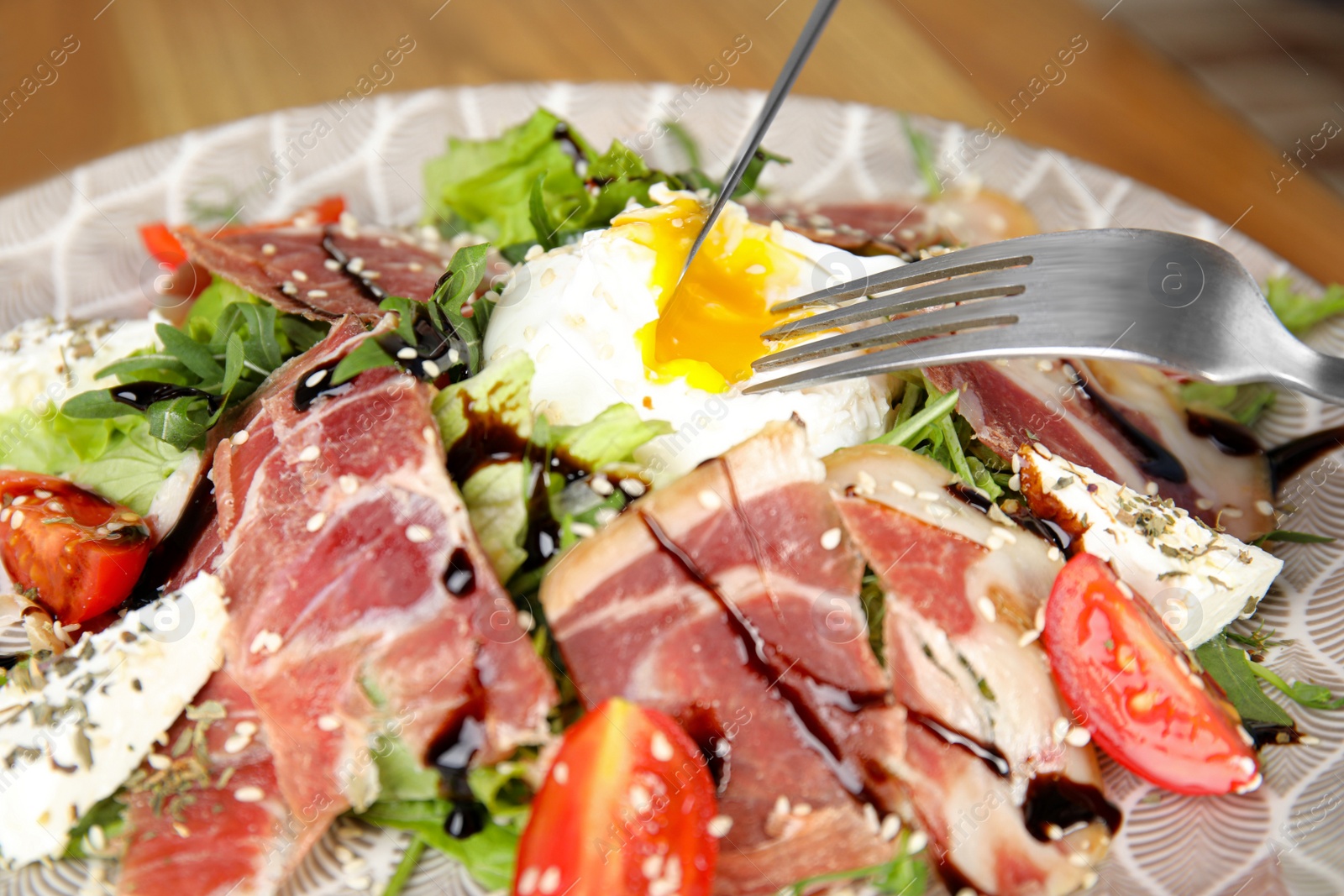 Photo of Delicious prosciutto salad with vegetables on plate, closeup