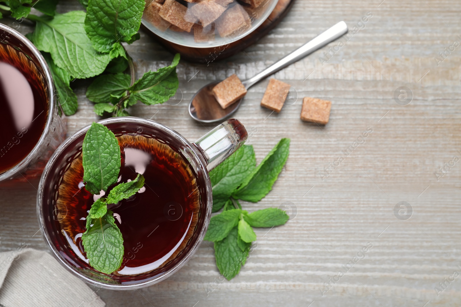 Photo of Flat lay composition with cup of hot aromatic mint tea on wooden table, space for text