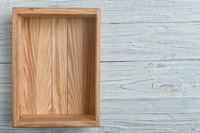 Photo of Empty crate on wooden background, top view with space for text