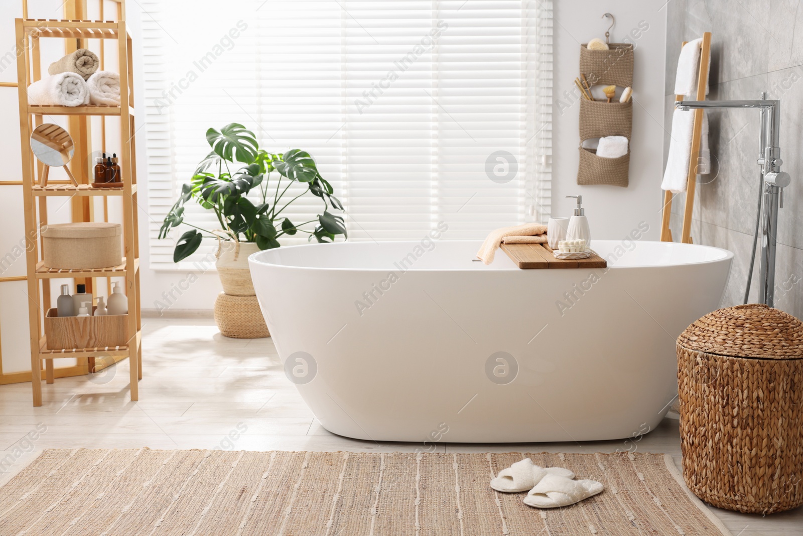 Photo of Set of different bath accessories and soap on tub in bathroom