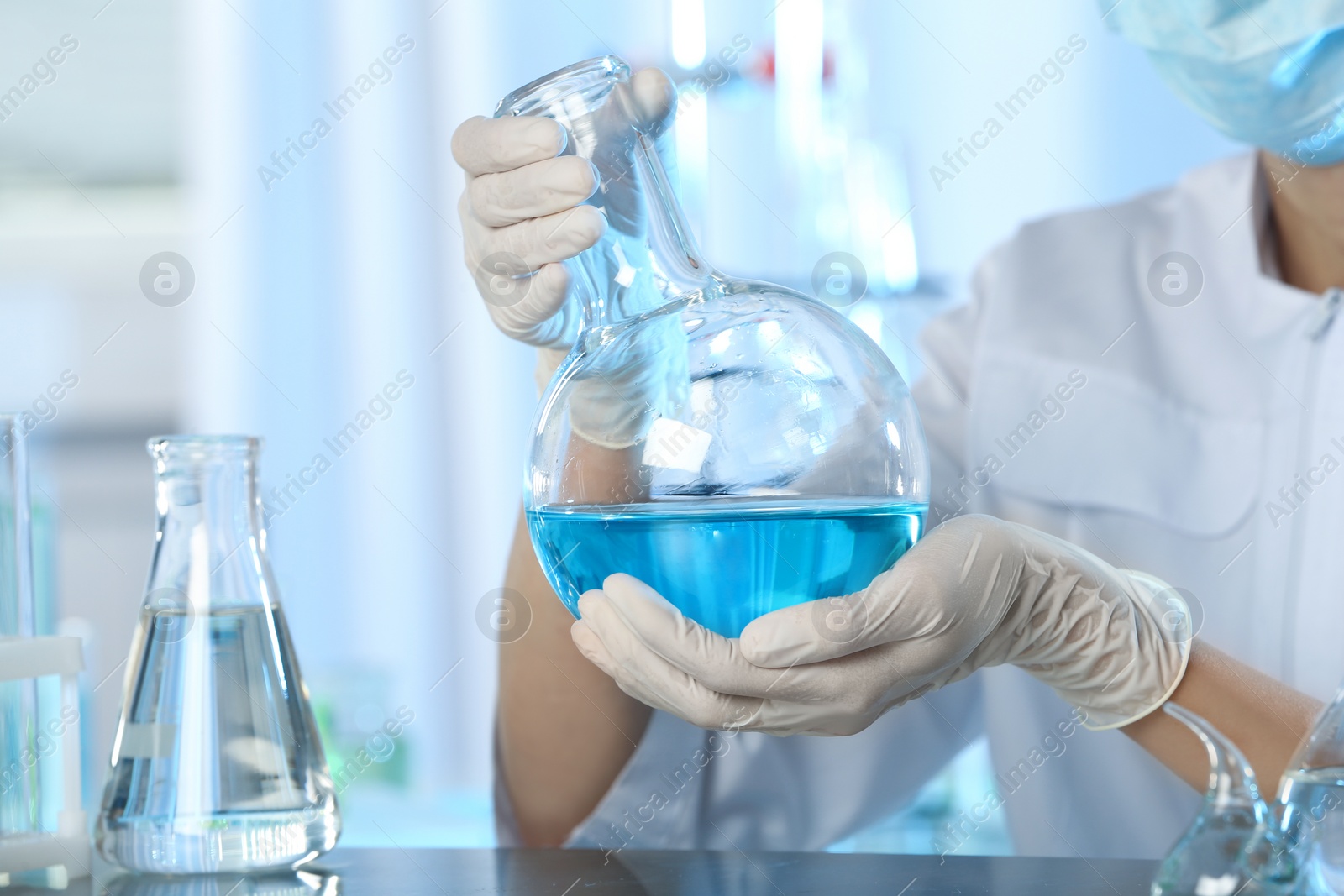 Photo of Doctor holding Florence flask with blue liquid, closeup. Laboratory analysis