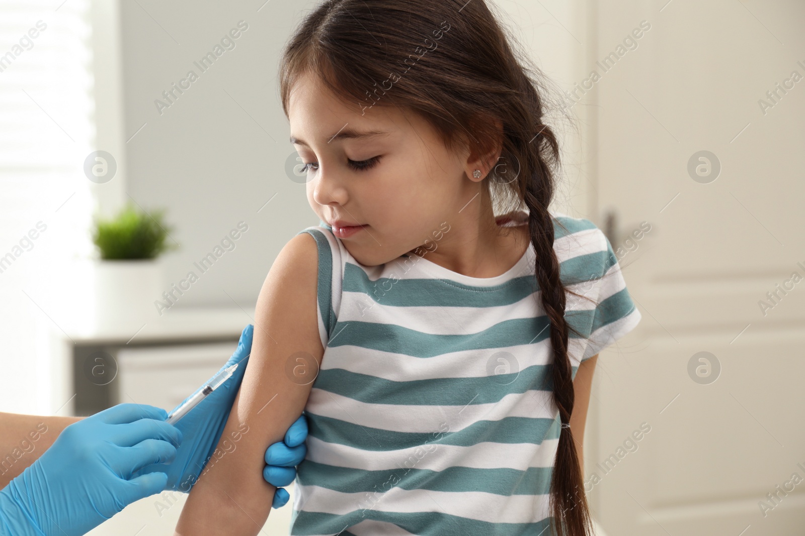 Photo of Doctor vaccinating little child in modern clinic