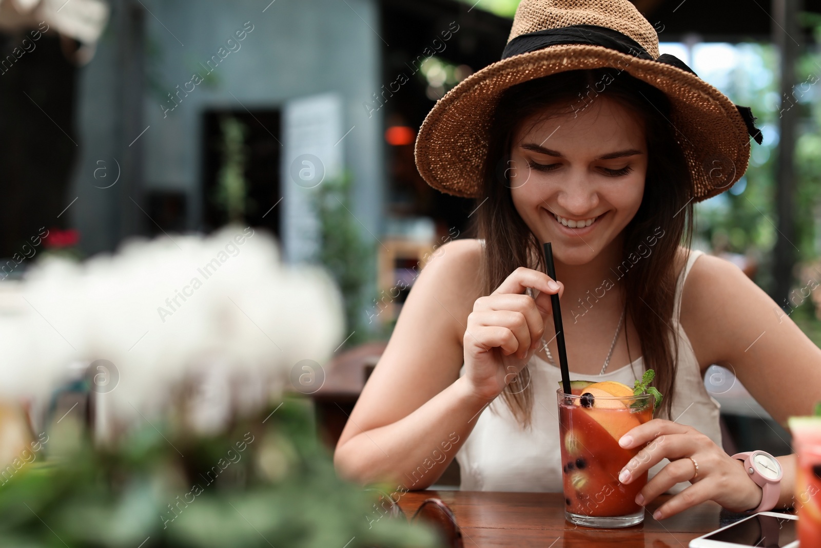 Photo of Woman with glass of tasty lemonade at table in cafe