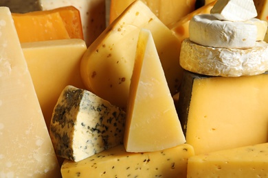 Different types of delicious cheese as background, closeup