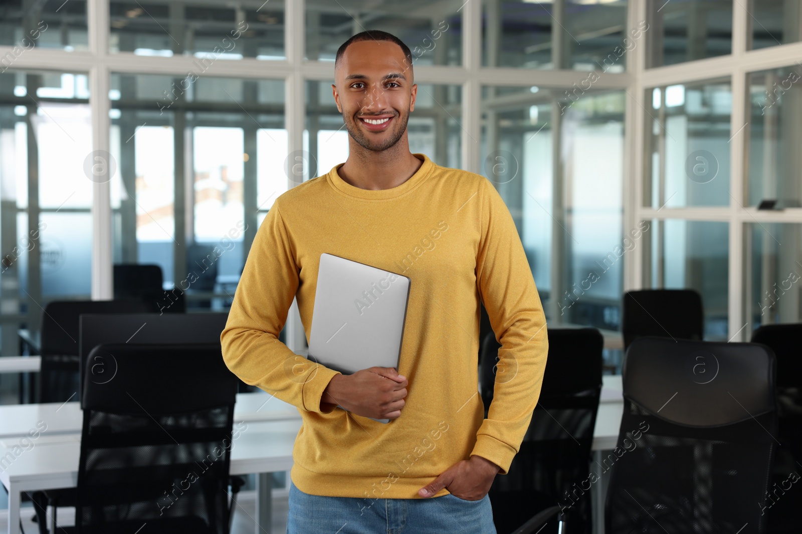 Photo of Handsome happy man with laptop in office