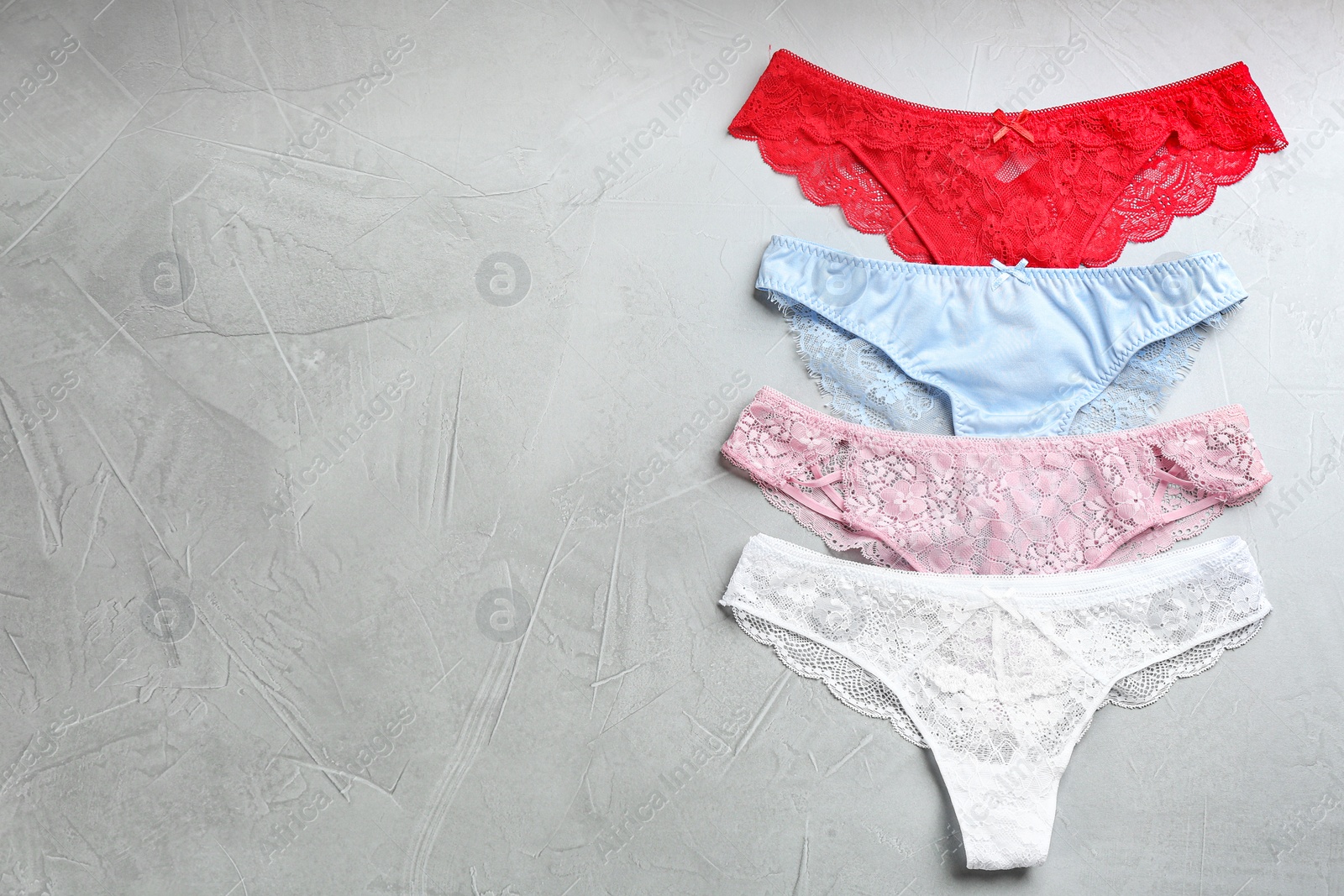 Photo of Sexy women's underwear on light grey background, flat lay. Space for text