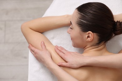 Photo of Woman receiving massage on couch in spa salon, top view