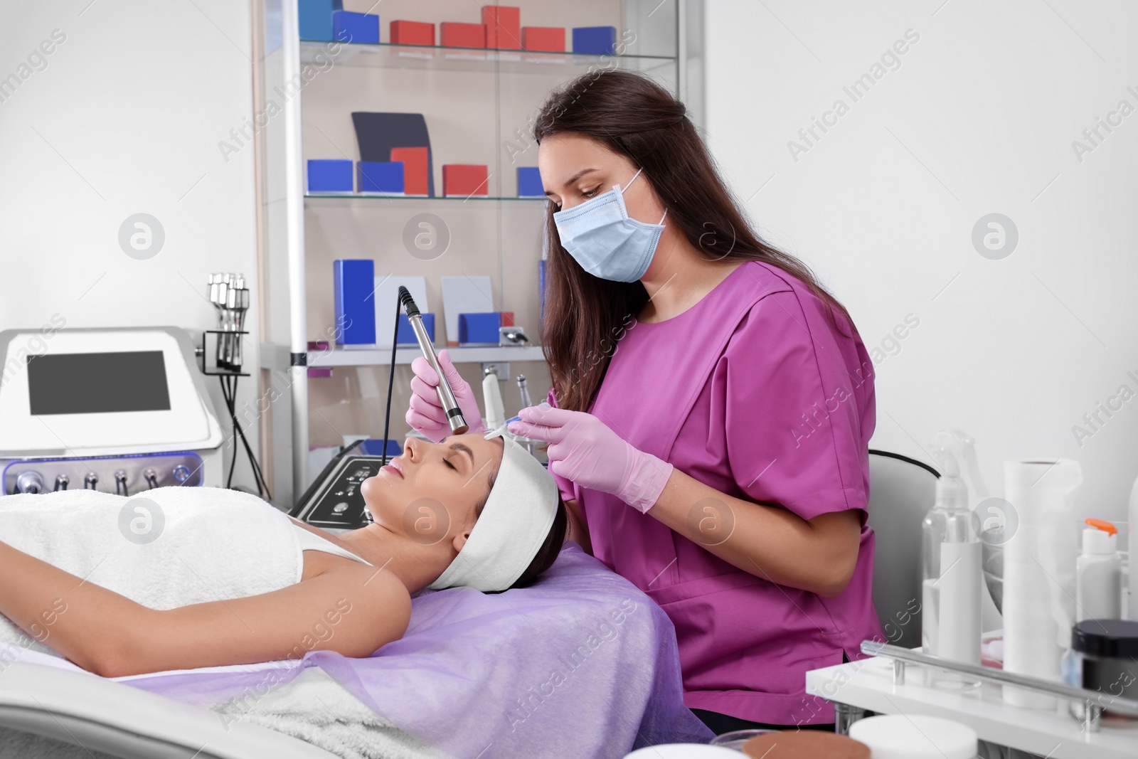 Photo of Young woman undergoing cosmetic procedure in beauty salon. Microcurrent therapy