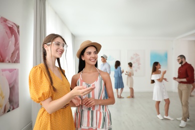 Young women at exhibition in art gallery