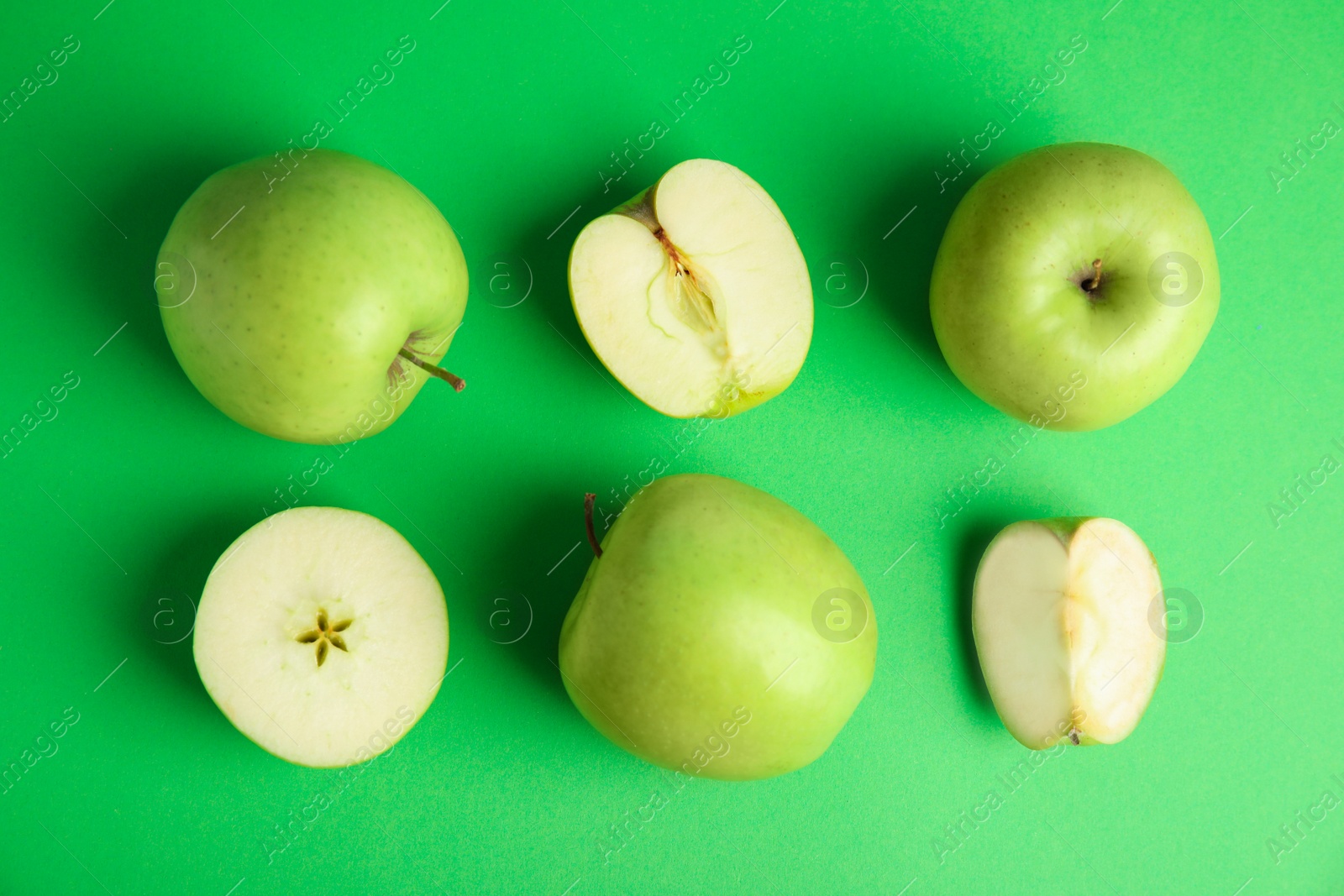 Photo of Flat lay composition of fresh ripe apples on green background