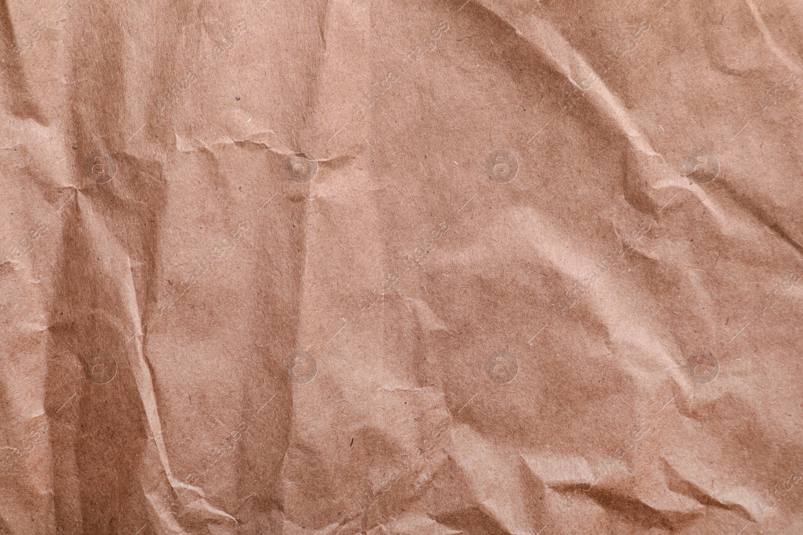 Photo of Texture of wrinkled kraft paper bag as background, closeup