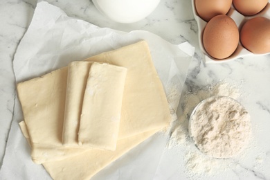 Photo of Fresh raw dough and ingredients on table