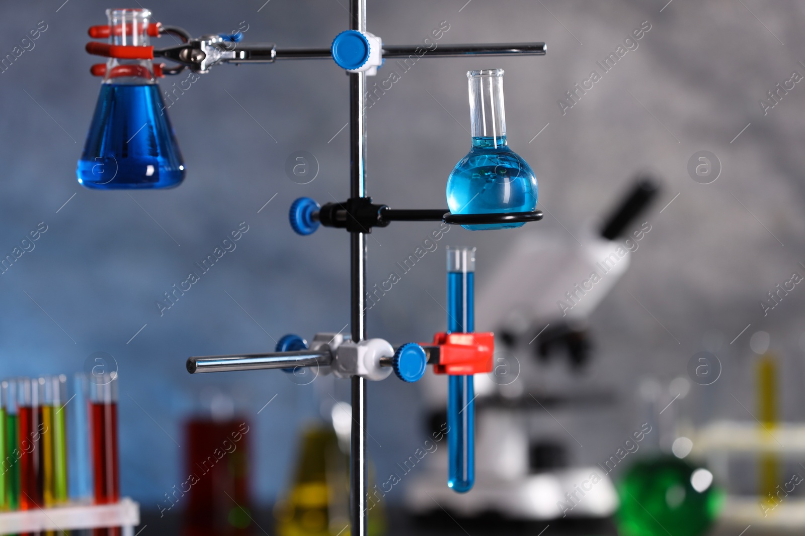 Photo of Laboratory glassware with blue liquid on retort stand indoors