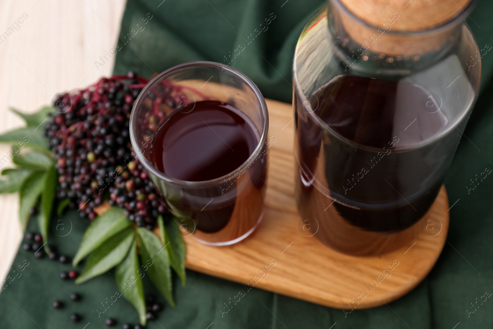 Photo of Elderberry drink and Sambucus berries on table, closeup