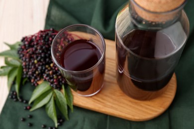 Elderberry drink and Sambucus berries on table, closeup