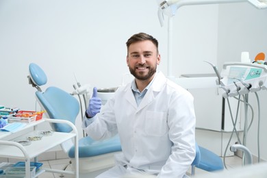 Portrait of professional dentist at workplace in clinic