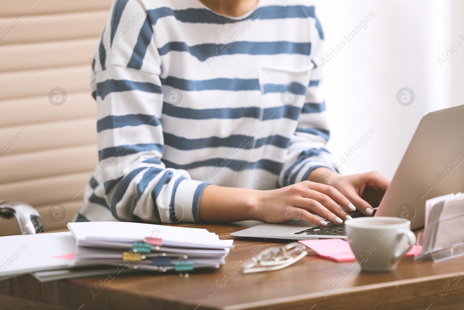 Image of Young journalist working with laptop in office, closeup