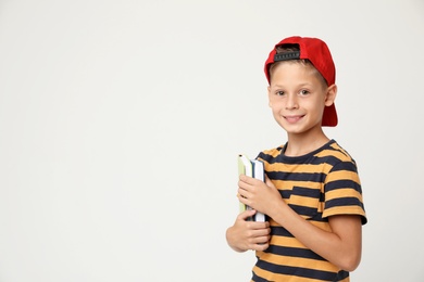 Portrait of cute little boy with books on grey background, space for text. Reading concept