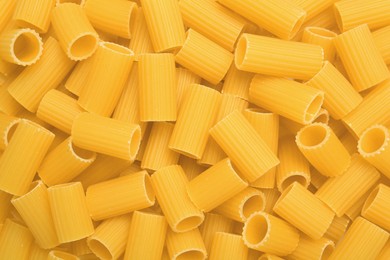 Photo of Raw rigatoni pasta as background, top view