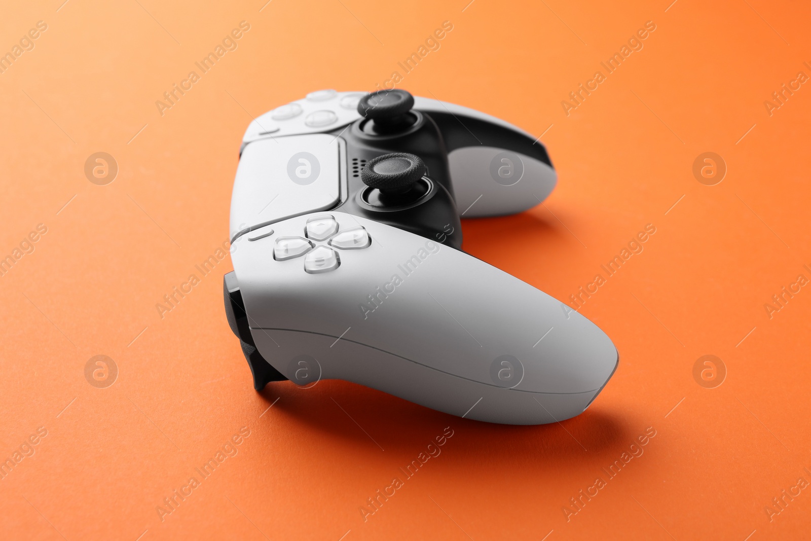 Photo of One wireless game controller on orange background