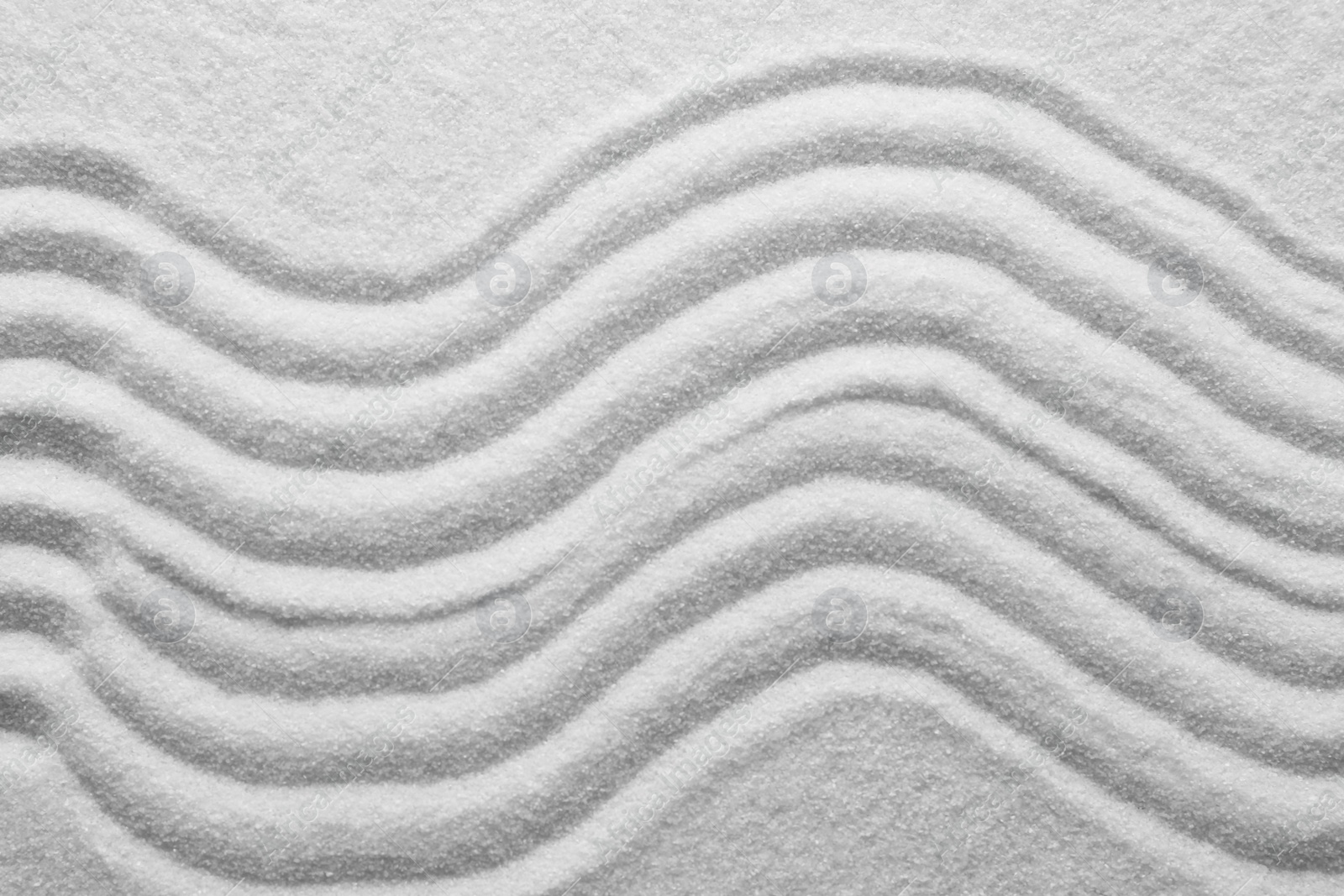 Photo of White sand with pattern as background, closeup. Concept of zen and harmony