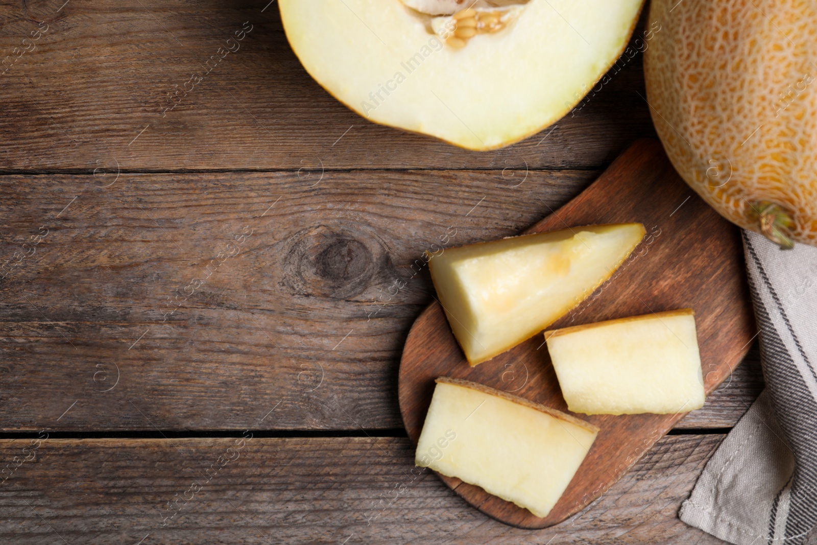 Photo of Delicious ripe melons on wooden table, flat lay. Space for text