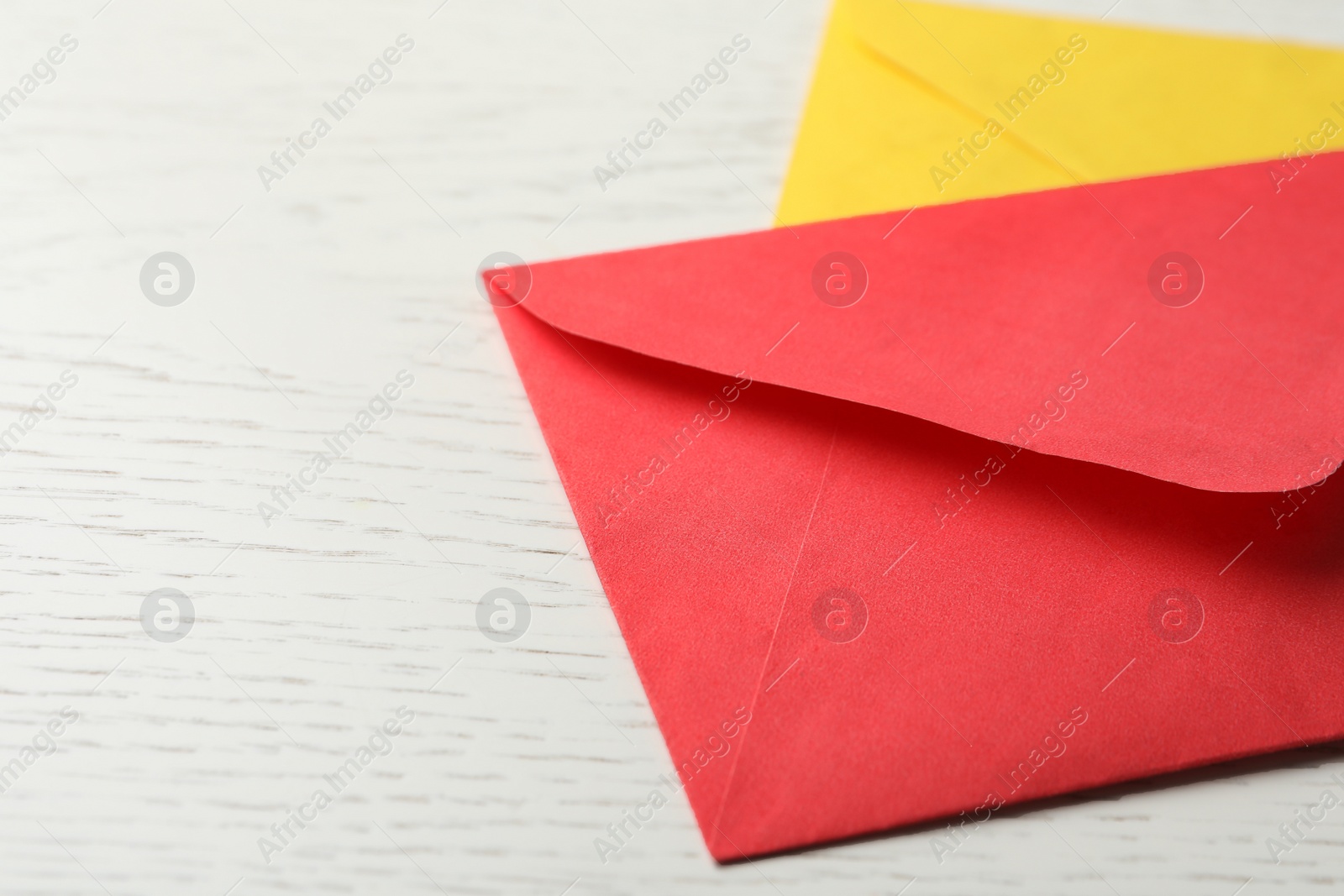 Photo of Paper envelopes on white wooden background, closeup