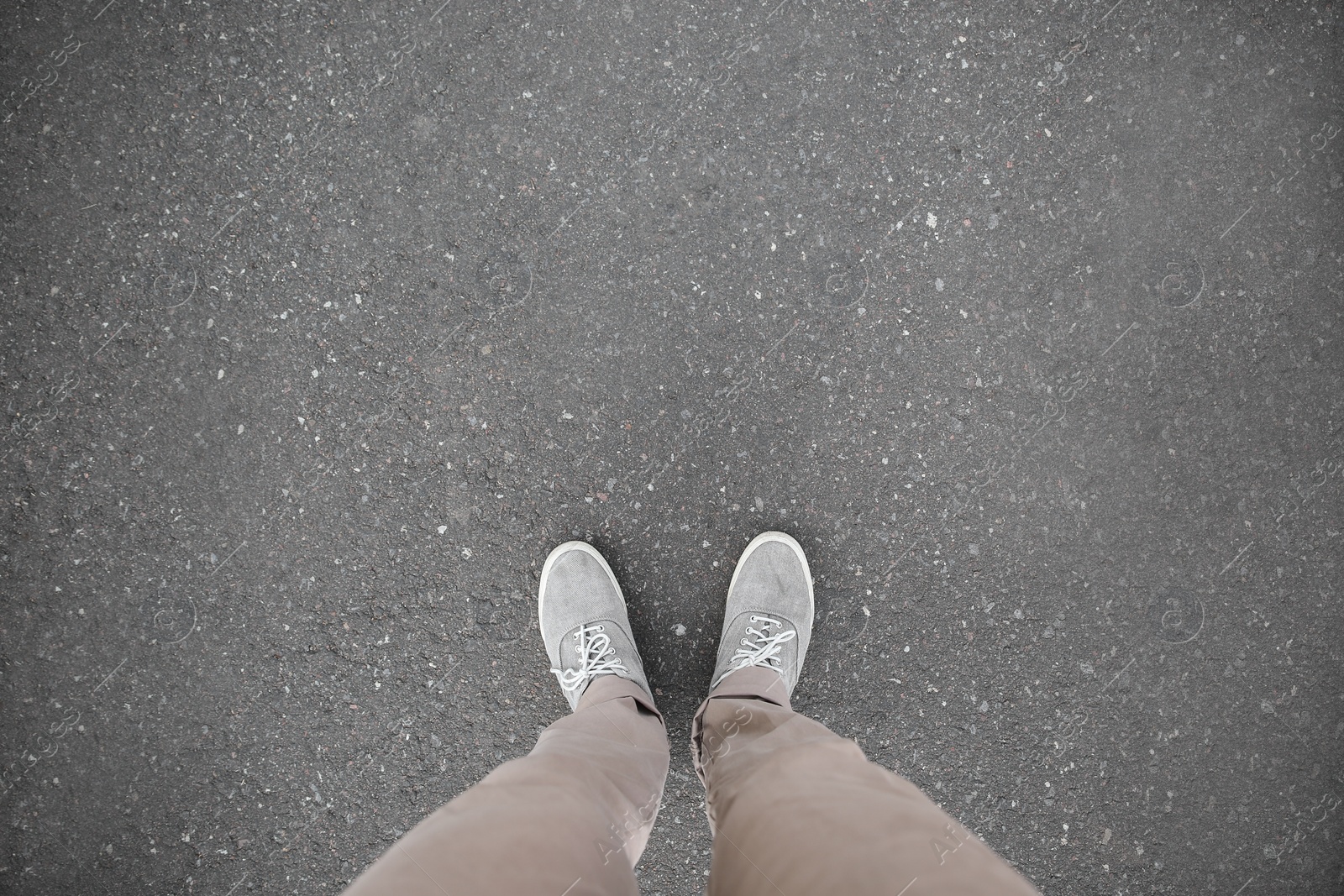 Photo of Man standing on asphalt road, top view. Space for text