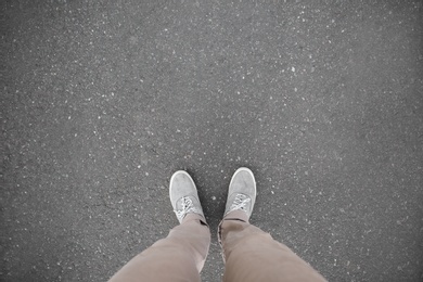 Photo of Man standing on asphalt road, top view. Space for text