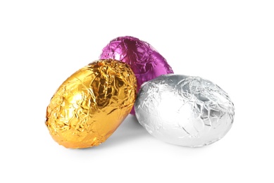 Photo of Chocolate eggs wrapped in colorful foil on white background