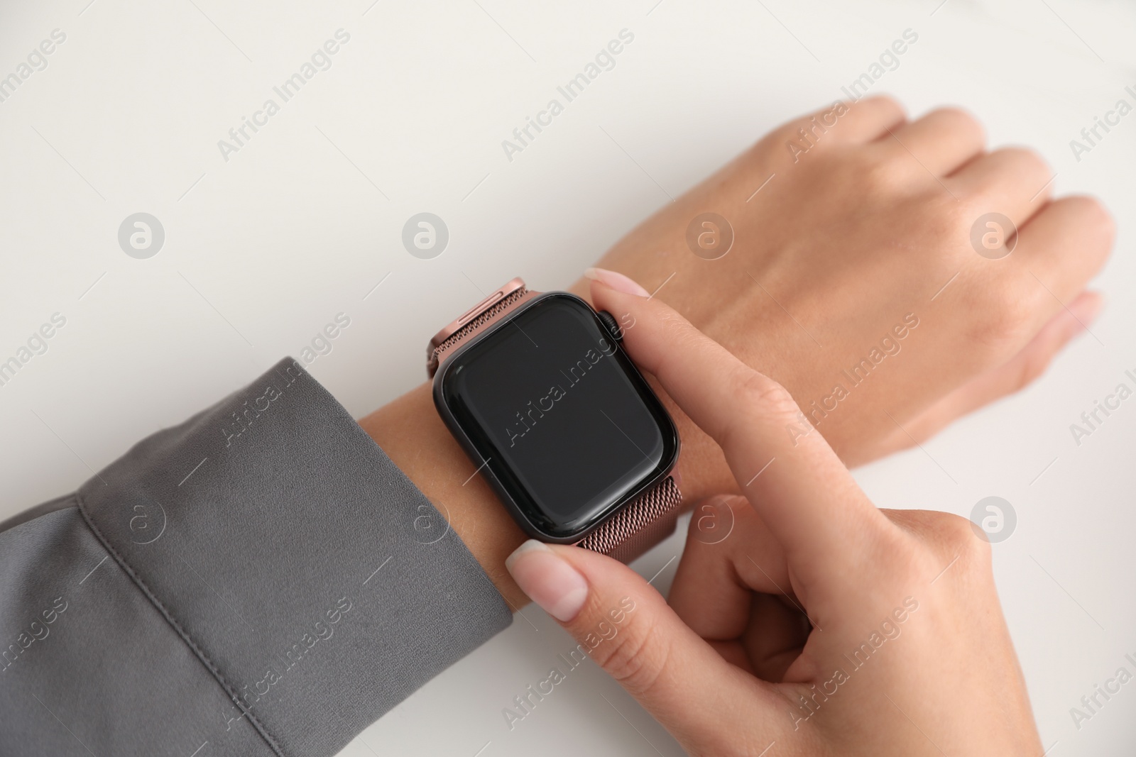 Image of Woman checking stylish smart watch on white background, closeup