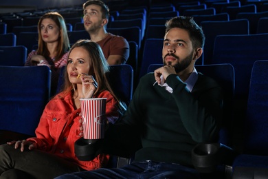 Young people watching movie in cinema theatre