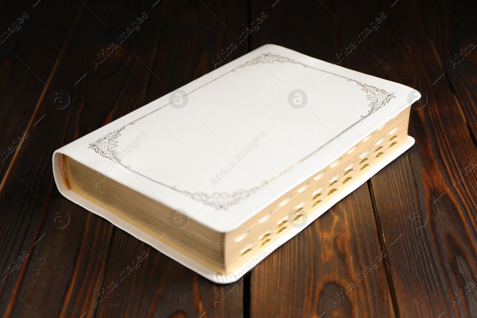 Photo of Old hardcover Bible on wooden table. Religious book