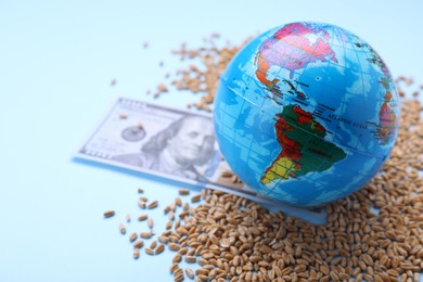 Photo of Import and export concept. Globe, wheat grains and money on light blue background. Space for text