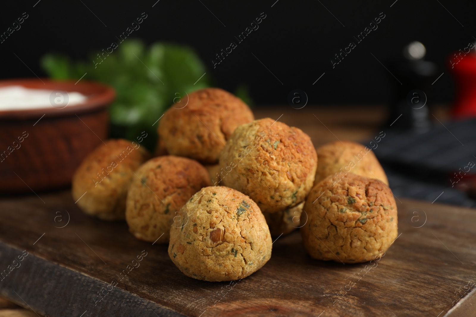 Photo of Delicious falafel balls on wooden board, closeup