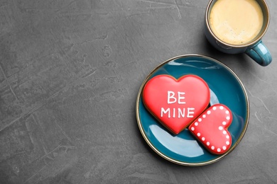 Cup of coffee and heart shaped cookies on grey table, flat lay with space for text. Valentine's day breakfast