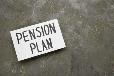 Photo of Card with words Pension Plan on grey table, top view. Space for text
