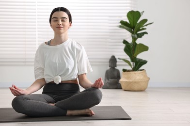 Photo of Beautiful girl meditating on mat in yoga studio