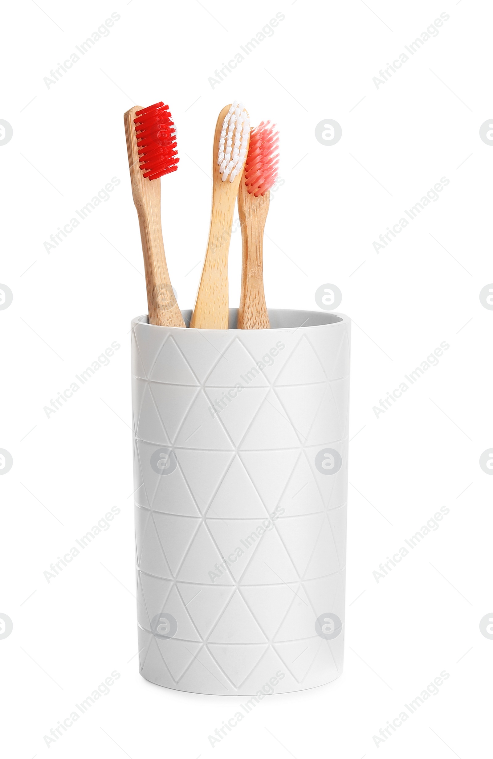 Photo of Bamboo toothbrushes in holder isolated on white