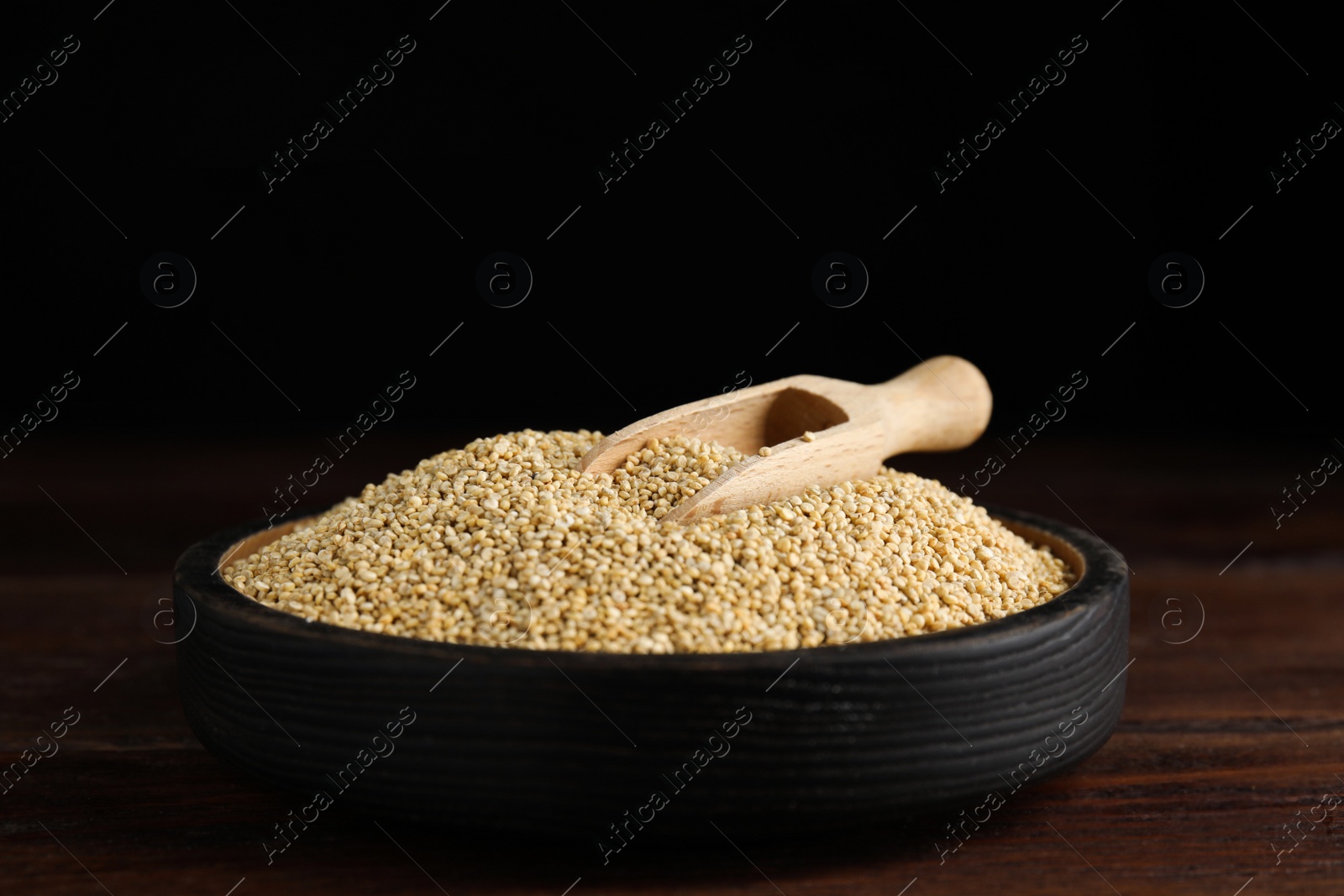 Photo of Plate with white quinoa and scoop on wooden table. Space for text