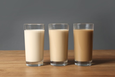 Photo of Glasses with protein shakes on wooden table