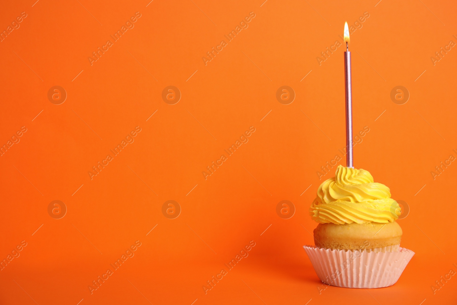 Photo of Birthday cupcake with candle on orange background, space for text